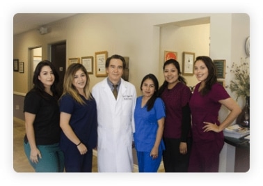 The care team in scrubs and a white coat standing together in an office hallway